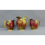 Group of three Carlton ware Rouge Royale 'Spiders Web' patterned jugs with gilt edge rims, handles