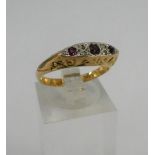 18 carat gold and platinum three stone ruby and diamond chip set dress ring.