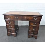 Mahogany desk with brown leather skivver and an arrangement of eight drawers, 80 x 108cm