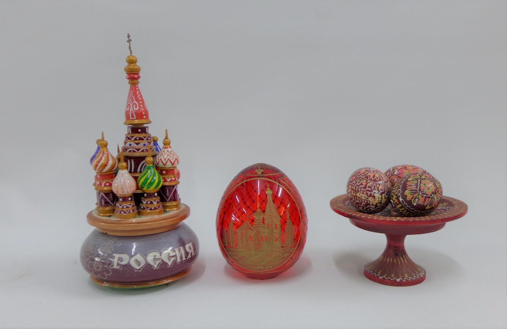 A collection of Russian trinkets to include a red glass egg, St Basils music box, etc