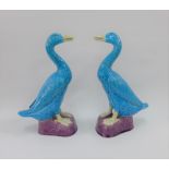 A pair of Chinese turquoise blue glazed duck figures on purple bases, 30cm high