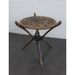An African style carved hardwood table with circular pierced top on a folding base, 60 x 53cm