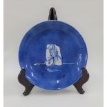 Chinese porcelain shallow dish, the blue ground painted with a figure to the centre,( fritting to
