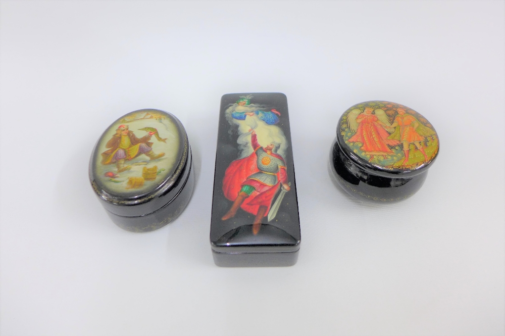 A collection of three Russian black lacquered boxes with painted lids, largest 13cm long (3)