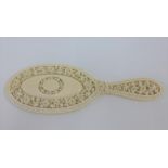Early 20th century ivory hand mirror intricately carved with flowers, 25cm long