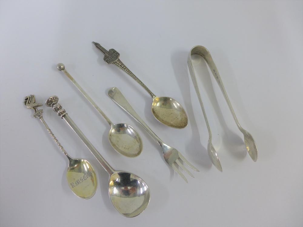 A group of silver and white metal spoons, pickle fork and sugar tongs, (6)