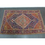 Persian rug with allover foliate pattern to a blue and rose coloured field, with flowerhead