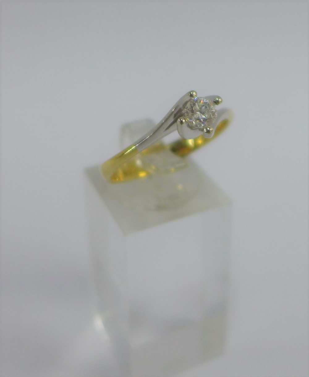 Diamond claw set solitaire ring on a plain white and yellow 18 carat gold band, full set of