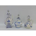 Three Delft blue and white pottery decanters with stoppers, tallest 29cm (3)