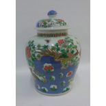 A large Chinese jar and cover decorated with peacock, butterfly, flowers and foliage, the vase