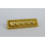 18 carat gold brooch set with five bright cut diamonds to an open rectangular plaque, 5cm long