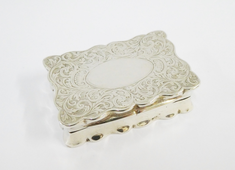 Edwardian silver snuff box, the wavy edged hinged top with an engraved scroll pattern and vacant