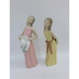 Two Lladro Diasa girl figures, one wearing a pink dress the other in yellow, with printed