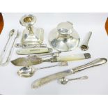 A collection of silver to include a capstan inkwell, sugar tongs, fruit knife, desk candlestick, etc