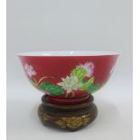 Red glazed chinoiserie bowl painted with flowers and foliage complete with circular hardwood