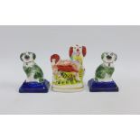 A pair of Staffordshire dogs on blue rectangular plinth bases, together with another larger, tallest