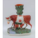 Staffordshire cow and calf spill vase on an oval gilt lined base, 27cm high