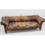 19th century button back Chesterfield sofa with worn leather upholstery and mahogany legs with brass