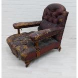 19th century worn leather buttonback library armchair,on mahogany legs with brass caps and