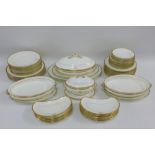 A quantity of Mintons white glazed table wares with 'Sans Regret' family crest and gilt edged