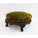 Early 20th century footstool with carved frieze and four scroll feet and upholstered circular top,