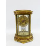 19th century French four glass panelled mantel clock in an oval case with floral swags, the brass