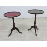 Two pedestal wine tables, with circular tops - one red the other green, on tripod legs, largest 56 x