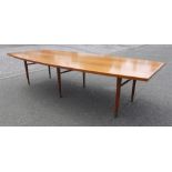 Large mid century teak dining table, circa 1950, of elliptical form on turned legs terminating on