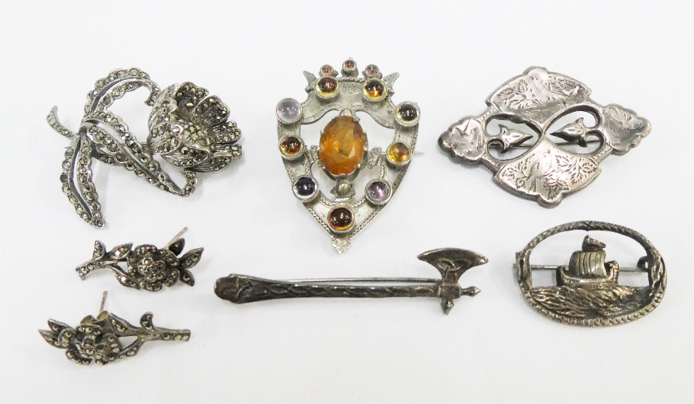 Mixed lot to include a hard stone shield brooch, three silver brooches and a marquisette brooch