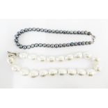 A single strand of large cultured pearls with a white metal ring clasp and a single strand of