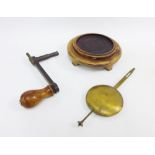 Clock winder, brass pendulum and a wooden stand, (3)