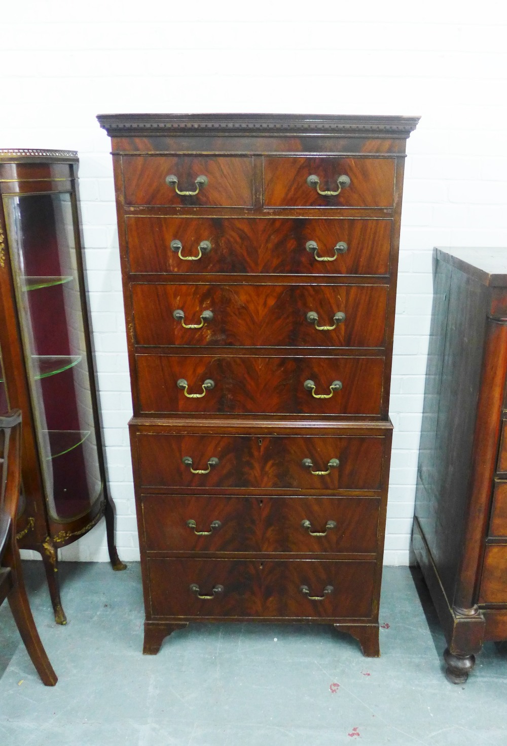 Mahogany veneered tallboy chest with a dentil frieze over two short and six long drawers, on bracket