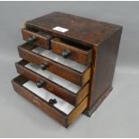 Stained pine miniature chest, with two short and three graduating long drawers, on a plinth base, 26