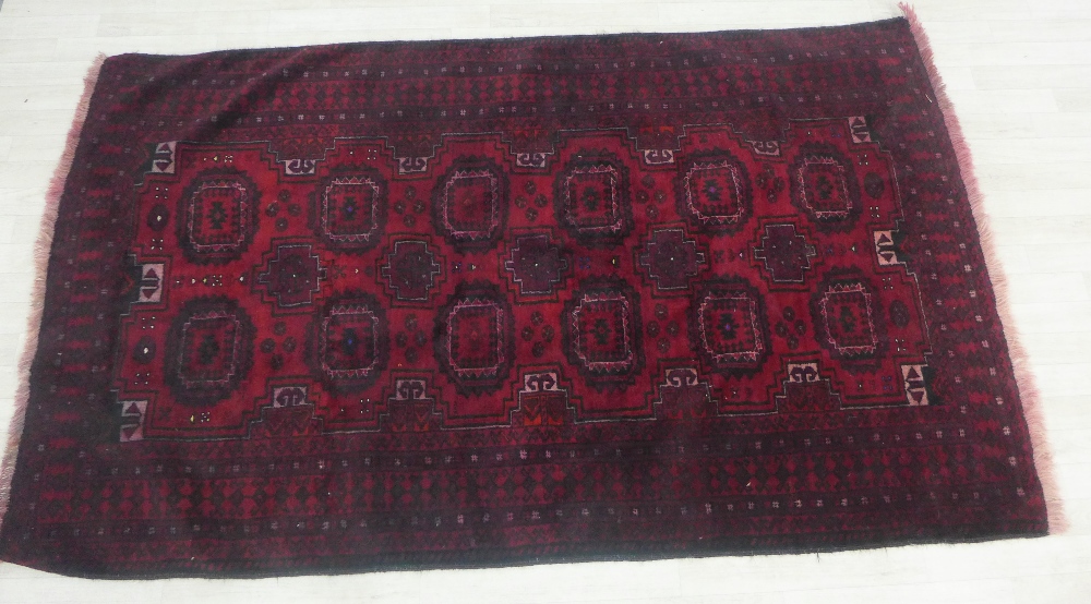 Bokhara type rug with red field and with two rows of six guls, geometric borders, 220 x 126cm