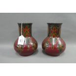 Plazuid Gouda pair of Art Pottery vases, each with red ground and dark green and yellow splash