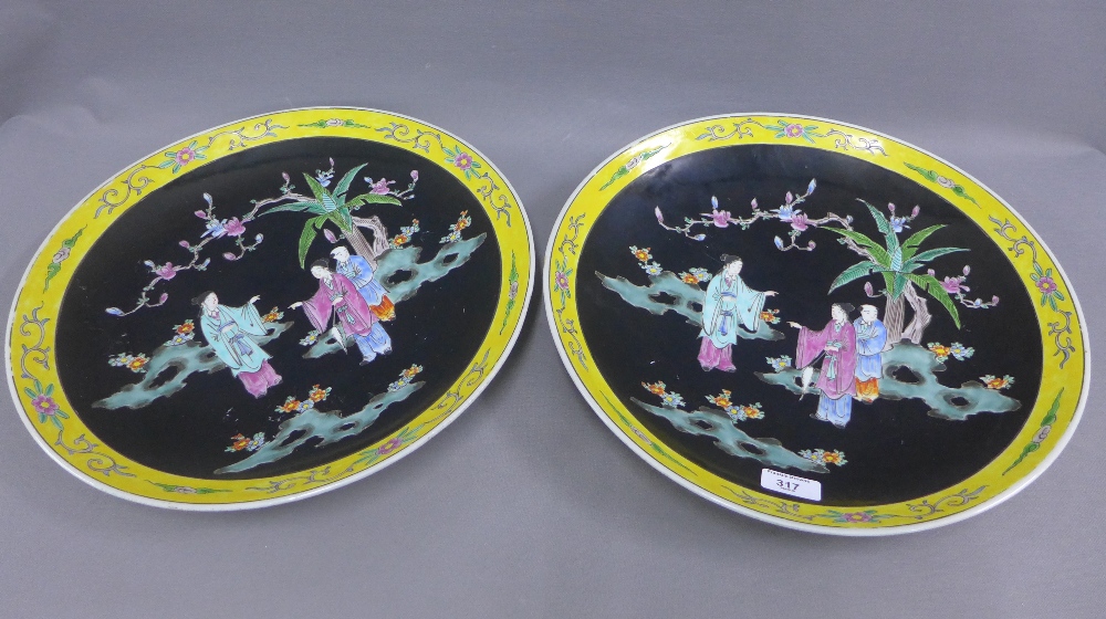 Pair of Chinese chargers, the black ground painted with figures within a yellow border, 40cm