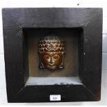 Carved wooden Buddha head, framed, size overall 34 x 34cm