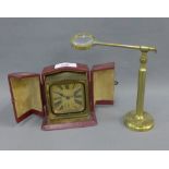 Early 20th century brass cased bedside / travel clock and a brass magnifying glass (2)