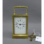 French brass and glass panelled carriage clock of small proportions, the enamel dial with Roman hour