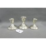 A pair of silver desk candlesticks, Birmingham 1972 and another larger candlestick, London 1908,