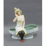 Continental bisque figure of a lady, modelled seated on the edge of a bath tub, 12cm high