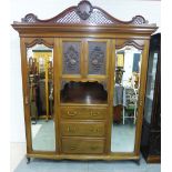 Mahogany wardrobe with a pierced pediment over two central carved doors flanked by mirrored doors,