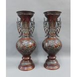 Pair of Japanese bronze vases with bird and flower pattern and pierced handles, on circular footrim,