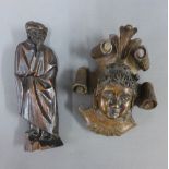 A carved wooden figure together with a face plaque, tallest 25cm