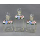 A set of three floral painted glass bottles with stoppers, tallest 16cm (3)