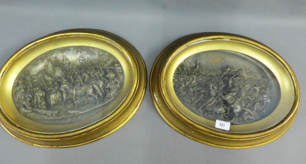 Pair of Justin Battle Scene metal plaques, each contained within a giltwood glazed showcase / frame,