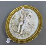 A giltwood oval plaque with two dancing figures