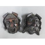 A pair of carved wooden face wall plaques, largest 16cm (2)