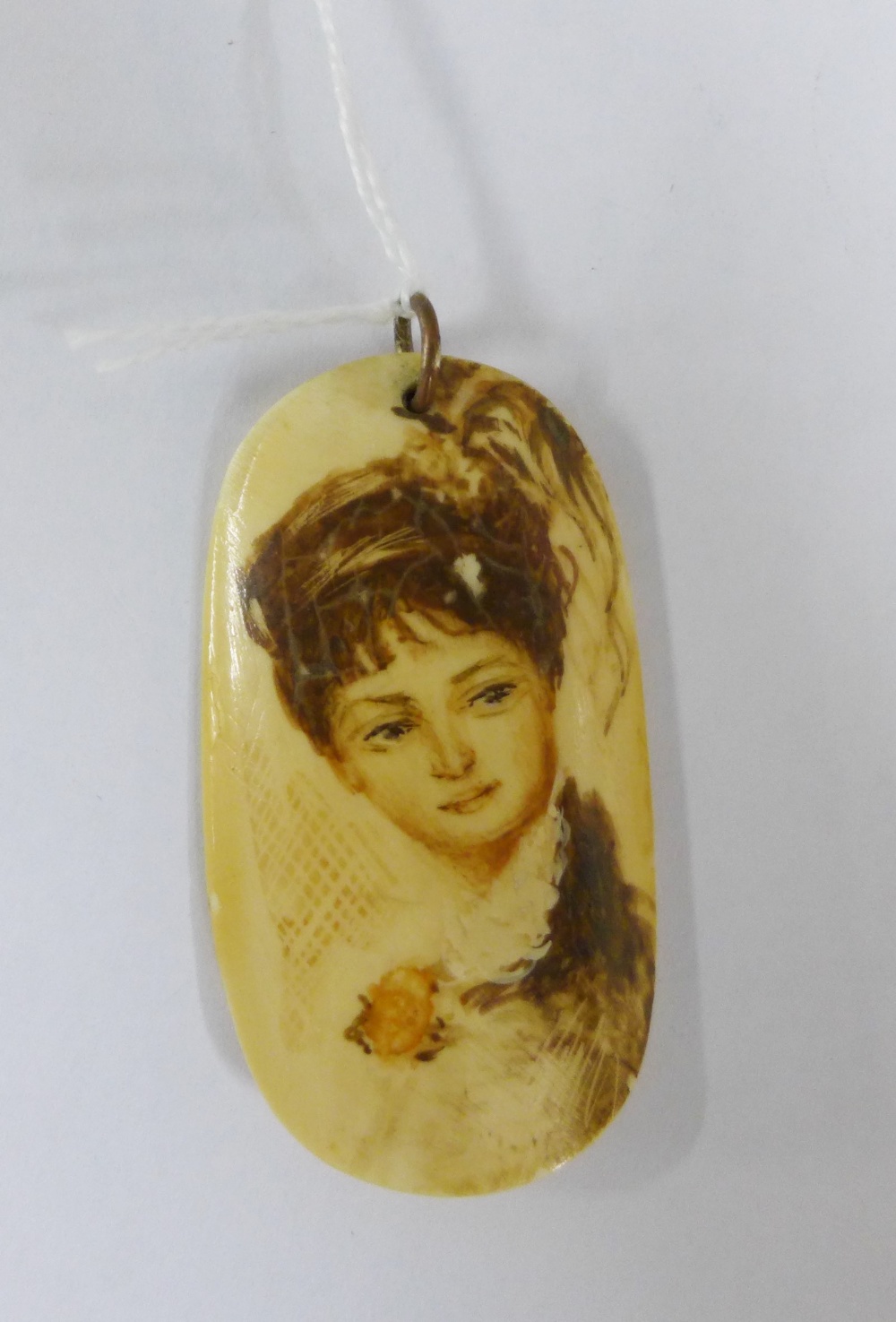 Late 19th / early 20th century marine ivory Scrimshaw pendant with a painted lady to front, marked