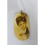 Late 19th / early 20th century marine ivory Scrimshaw pendant with a painted lady to front, marked